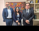 Foto de dois homens e uma mulher de pé e sorrindo.