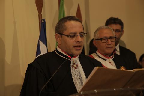 homem de toga em frente a uma tribuna discursando