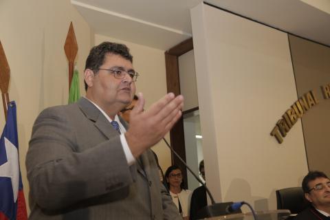 homem de toga em frente a uma tribuna discursando
