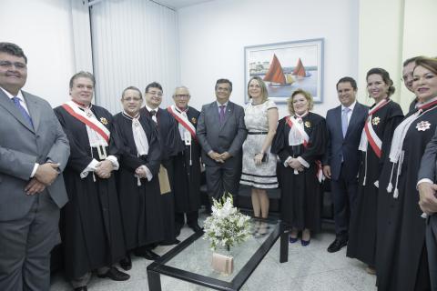 12 autoridades em pé pousando para foto, umas de terno e vestido outras de toga