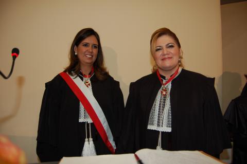 duas mulheres vestidas de toga em pé pousando para foto