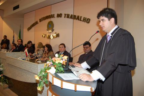 homem de toga em frente a uma tribuna discursando