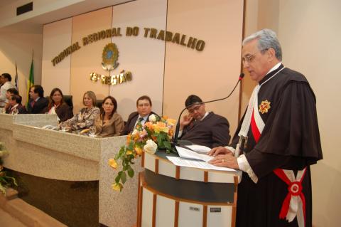 homem de toga em frente a uma tribuna discursando